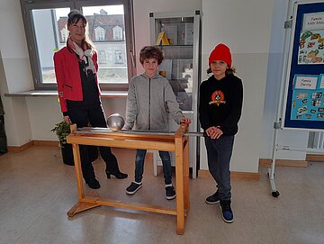 Gemeinsam mit Schulleiterin Claudia Schöll entdecken Schüler*innen spielerisch die Hintergründe technisch-naturwissenschaftlicher Phänomene (©Claudia Schöll).