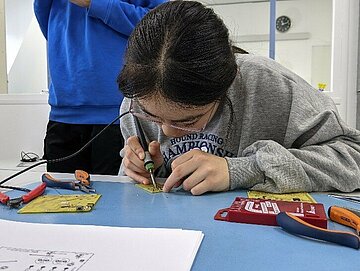 Linda (14 J.) lötet verschiedene elektronische Bauteile auf eine Platine. (Bildquelle: Nina Punger)
