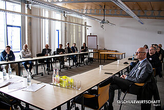 Personen in einem Konferenzraum bei einem Vortrag.