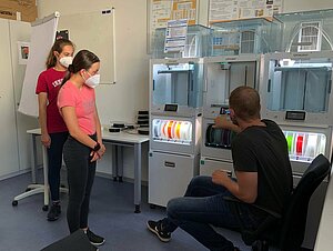 Philip Mosler (Hochschule Augsburg) erklärt den Teilnehmerinnen Annunciata und Lena die Funktionen des 3D-Druckers © Jacqueline Klemm